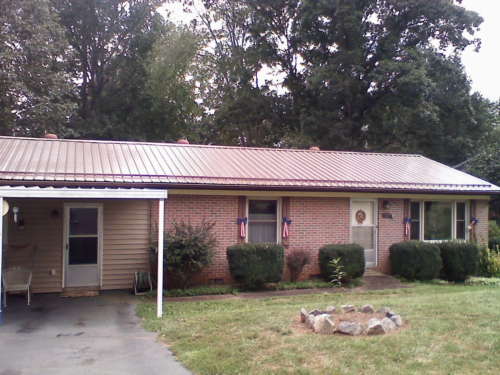 Bronze metal roof and carport on a brick ranch home — Roof Repair work by our crew in Fredericksburg